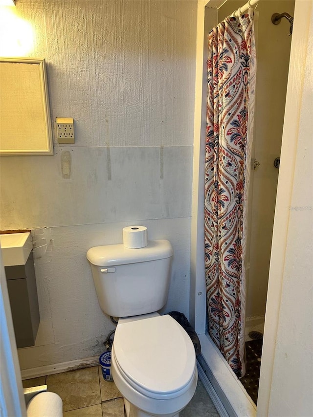 bathroom with a shower with shower curtain, tile patterned floors, and toilet