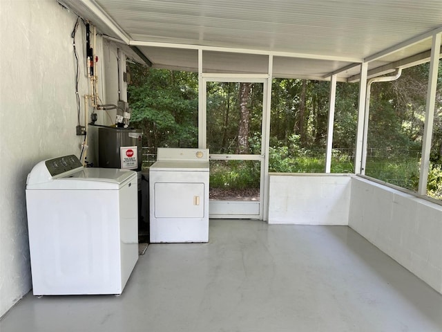 unfurnished sunroom featuring separate washer and dryer and water heater