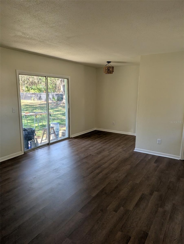 empty room featuring a textured ceiling and dark wood-type flooring