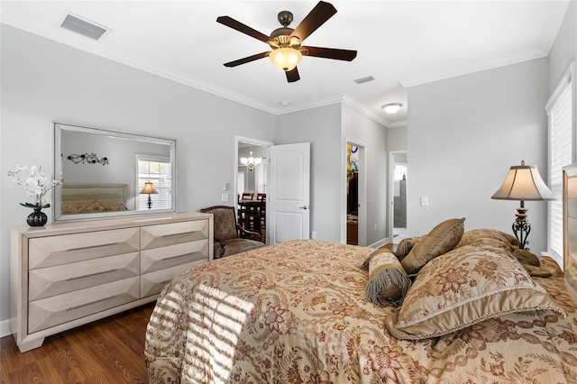 bedroom with a spacious closet, crown molding, a closet, dark wood-type flooring, and ceiling fan