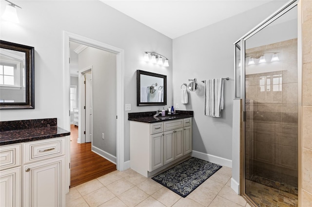 bathroom with vanity, tile patterned floors, and a shower with door