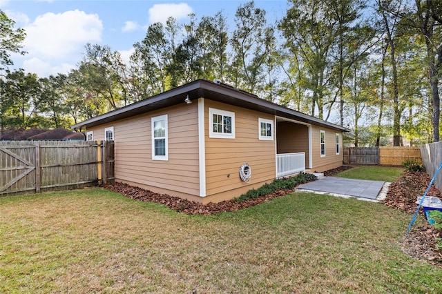 back of house with a patio and a lawn