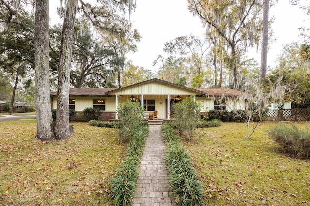 single story home with covered porch and a front yard