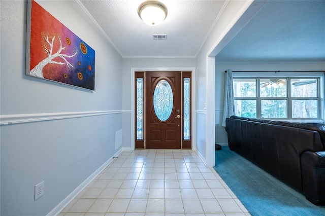 foyer with ornamental molding and a textured ceiling