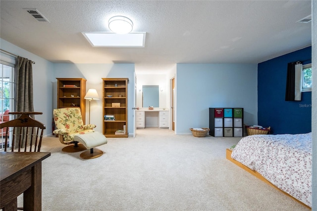 bedroom featuring connected bathroom, carpet floors, and a textured ceiling