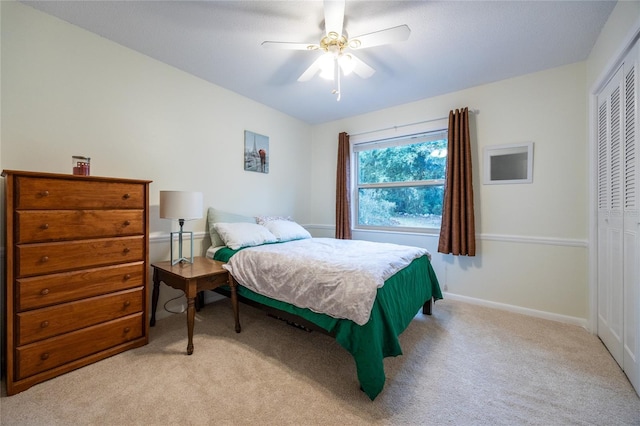 bedroom featuring ceiling fan, a closet, and light carpet