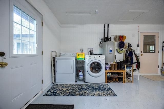 clothes washing area featuring water heater and independent washer and dryer