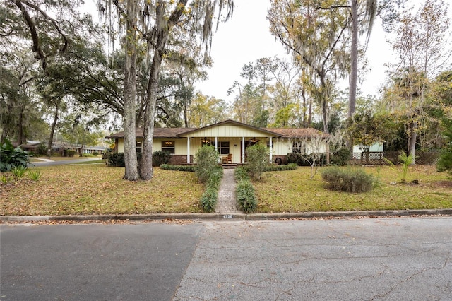 single story home with a porch and a front lawn