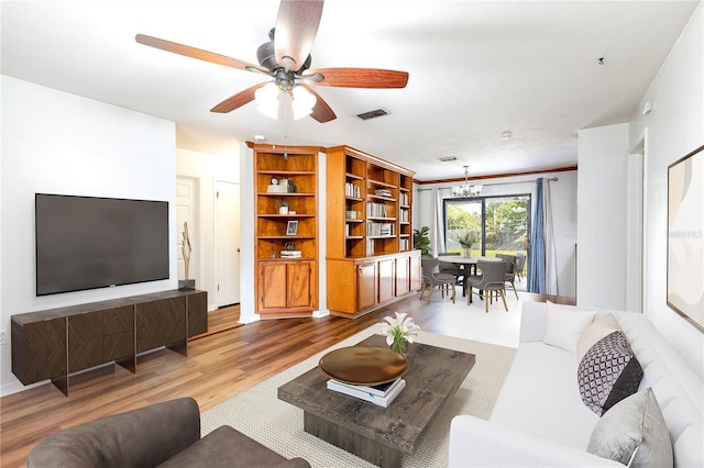 living room featuring hardwood / wood-style floors and ceiling fan with notable chandelier