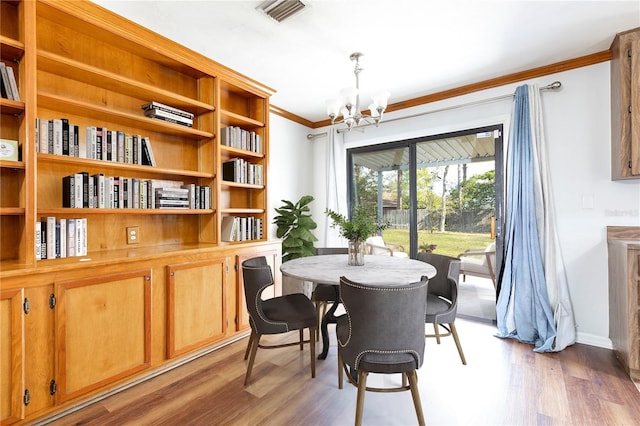 dining room with ornamental molding, light hardwood / wood-style floors, and an inviting chandelier