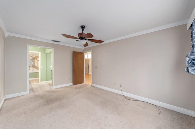 interior space with ceiling fan, ensuite bathroom, crown molding, and light carpet