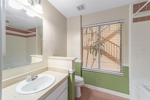 full bathroom with tile patterned flooring, vanity, toilet, and tiled shower / bath