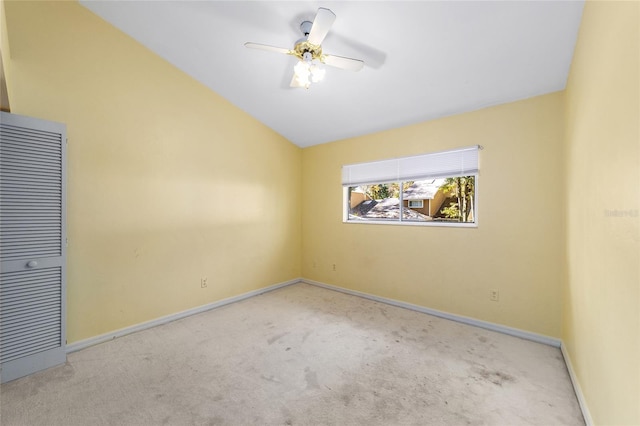 carpeted empty room with ceiling fan and lofted ceiling