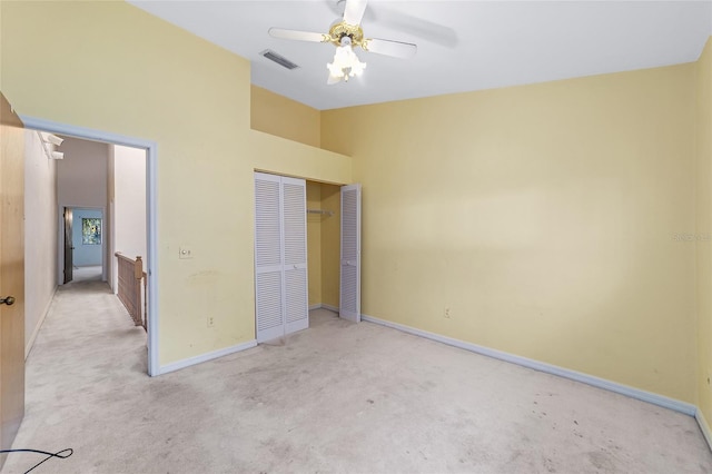 unfurnished bedroom featuring ceiling fan, light colored carpet, and a closet