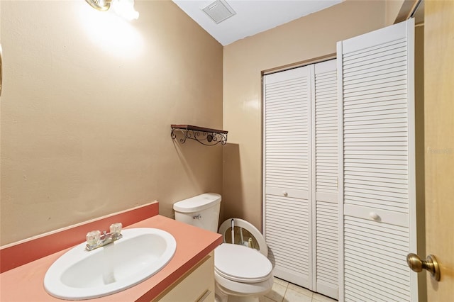 bathroom with tile patterned flooring, vanity, lofted ceiling, and toilet