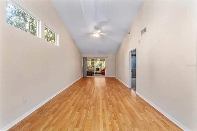 corridor with light hardwood / wood-style flooring and high vaulted ceiling