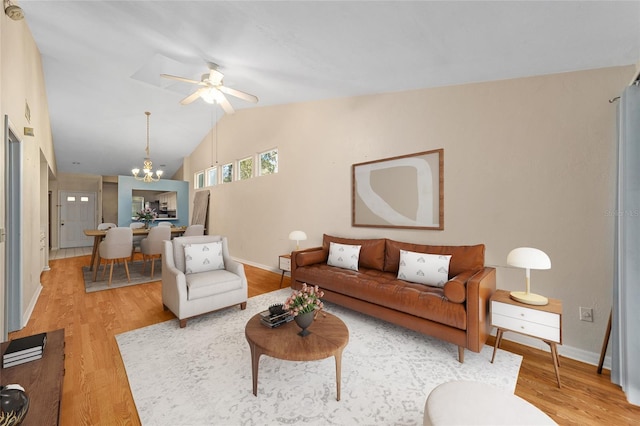 living room featuring hardwood / wood-style floors, ceiling fan with notable chandelier, and vaulted ceiling