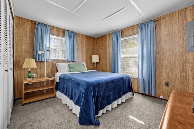 bedroom with carpet, wood walls, and a closet