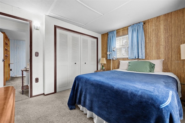 bedroom with carpet flooring, a closet, and wood walls