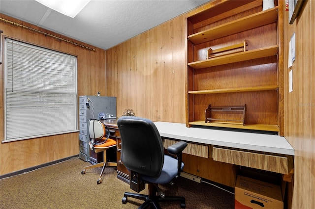 home office with carpet, a textured ceiling, and wood walls