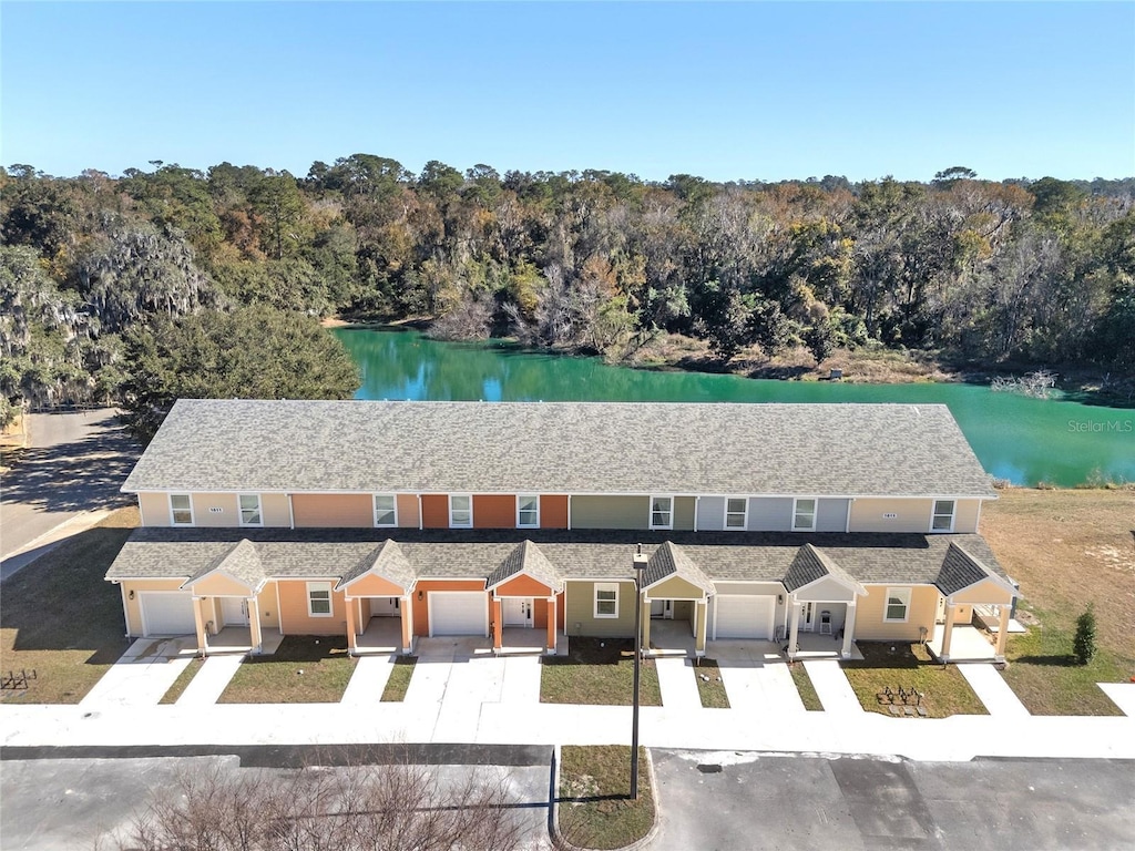 drone / aerial view with a water view and a forest view