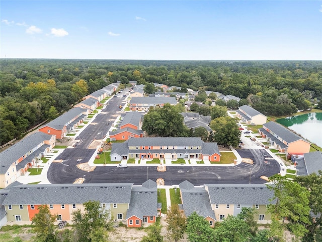 birds eye view of property featuring a water view, a residential view, and a wooded view