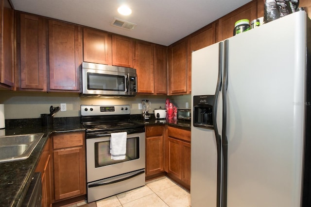 kitchen featuring sink, light tile patterned floors, and stainless steel appliances