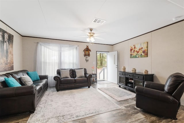 living room featuring dark hardwood / wood-style flooring, ceiling fan, and crown molding