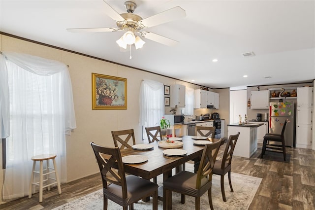 dining area with crown molding, dark hardwood / wood-style flooring, and ceiling fan