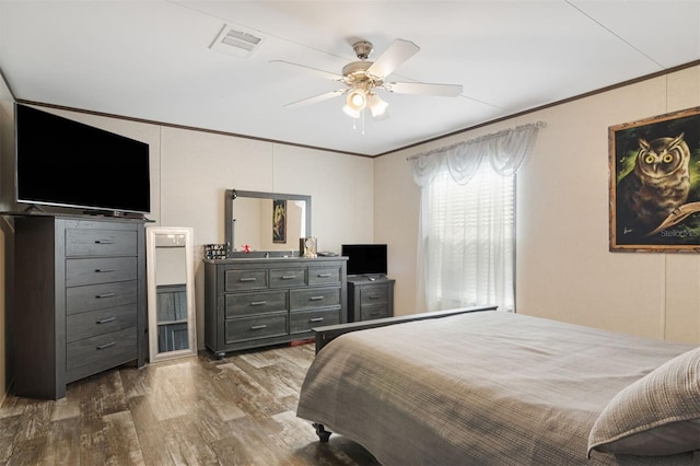 bedroom featuring ceiling fan, dark hardwood / wood-style floors, and ornamental molding