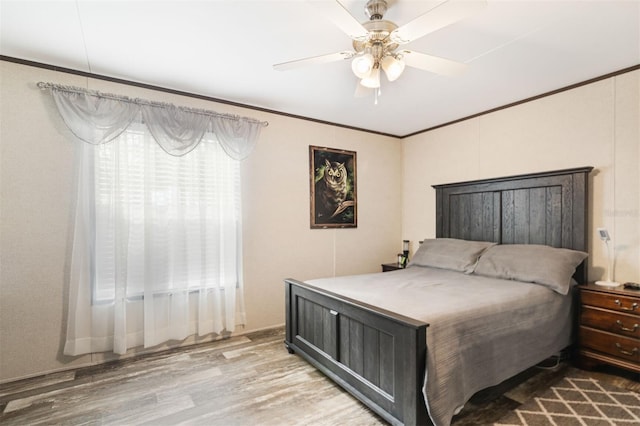 bedroom with ceiling fan, crown molding, and light hardwood / wood-style flooring