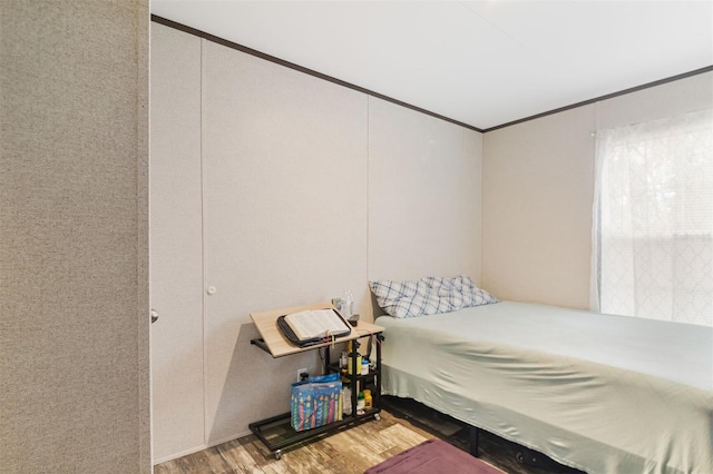 bedroom with hardwood / wood-style floors and ornamental molding