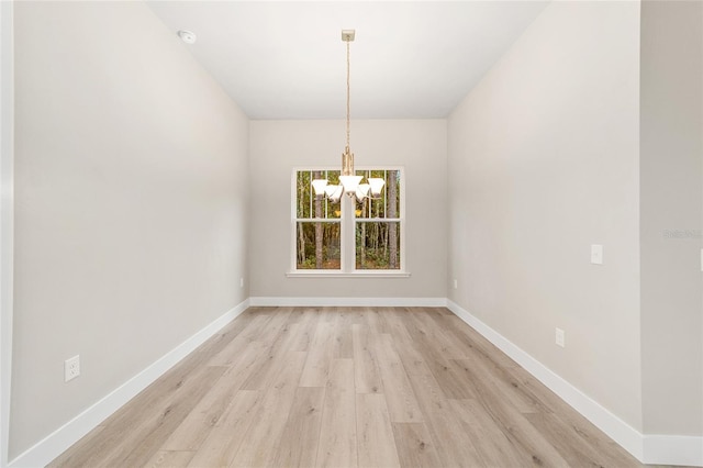 unfurnished dining area featuring light hardwood / wood-style flooring and a chandelier