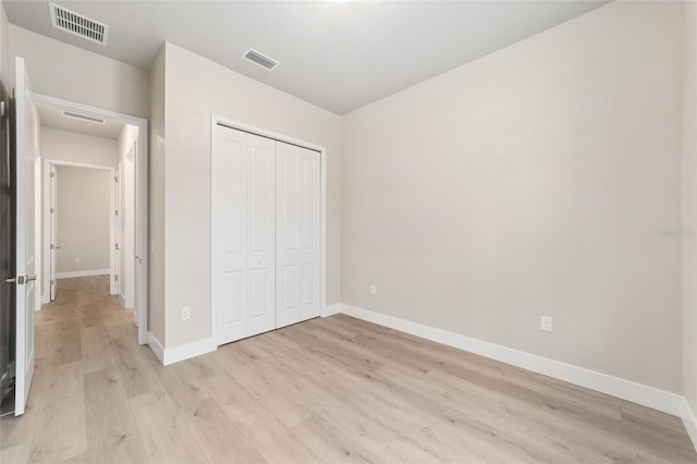 unfurnished bedroom featuring light wood-type flooring and a closet