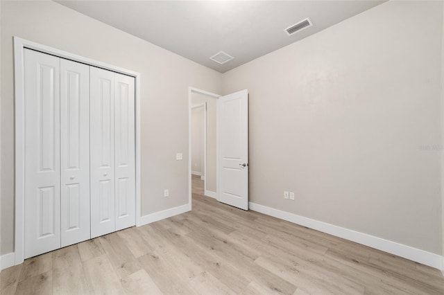 unfurnished bedroom featuring light hardwood / wood-style flooring and a closet