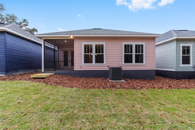 rear view of house with a lawn, a sunroom, and cooling unit