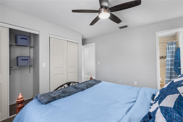 bedroom featuring ceiling fan, two closets, and ensuite bath