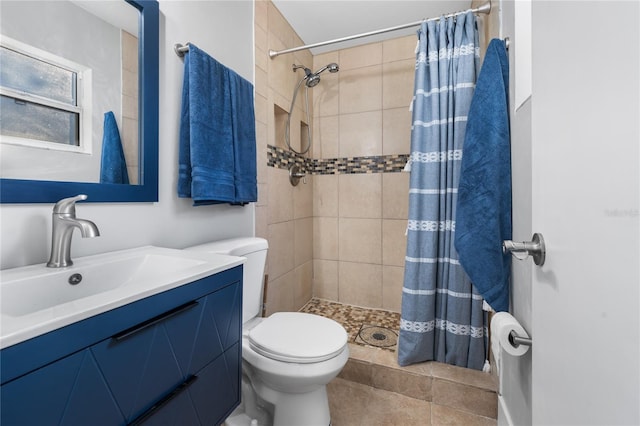 bathroom featuring tile patterned flooring, vanity, toilet, and curtained shower