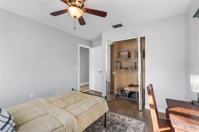 bedroom featuring dark hardwood / wood-style flooring, ceiling fan, and a closet