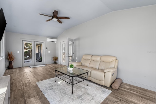 living room featuring hardwood / wood-style floors, french doors, an AC wall unit, vaulted ceiling, and ceiling fan