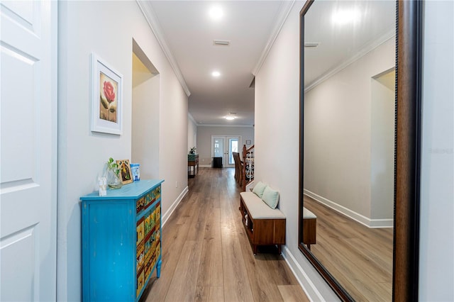 corridor featuring light wood-type flooring and ornamental molding