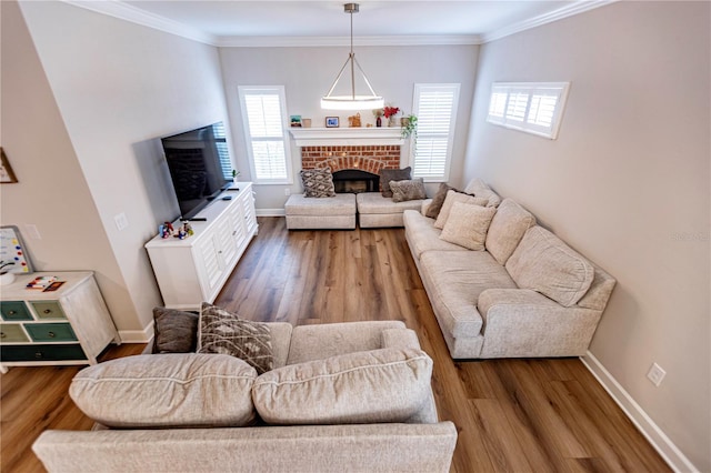 living room featuring hardwood / wood-style flooring, a brick fireplace, and crown molding