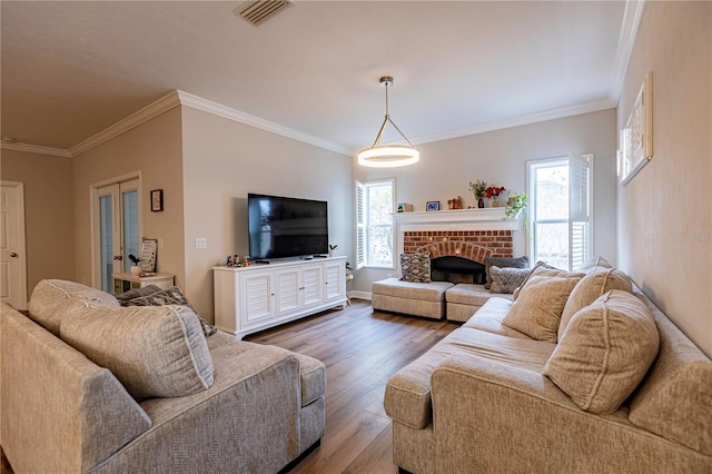 living room with hardwood / wood-style floors, a brick fireplace, and ornamental molding