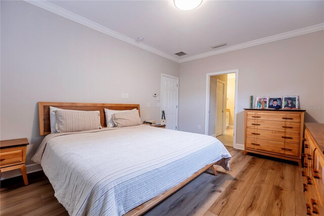 bedroom with wood-type flooring and crown molding