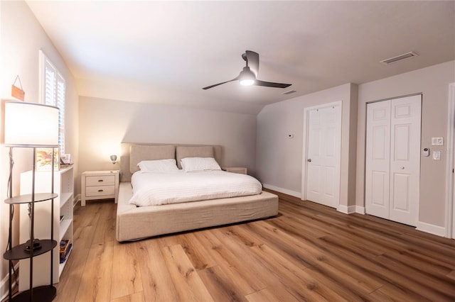 bedroom featuring ceiling fan, light hardwood / wood-style floors, and lofted ceiling