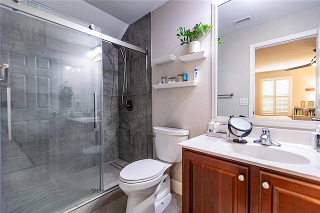 bathroom featuring tile patterned flooring, vanity, toilet, and walk in shower