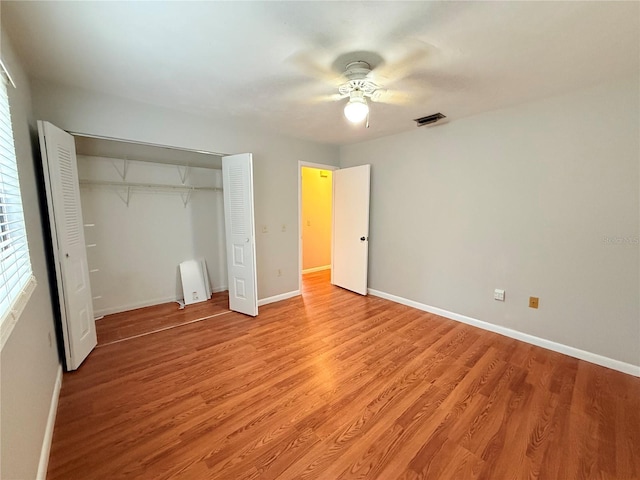 unfurnished bedroom featuring ceiling fan, a closet, and light wood-type flooring