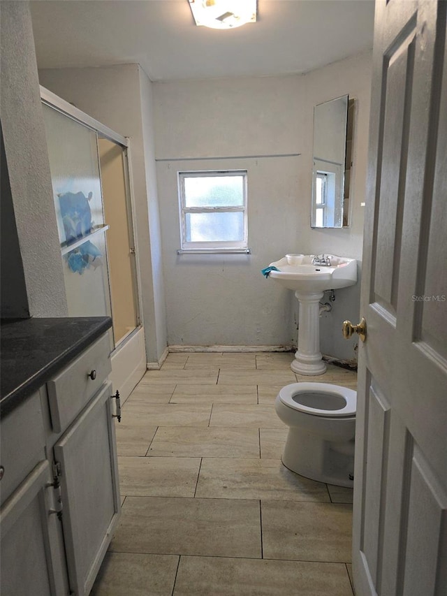 bathroom with shower / bath combination with glass door and toilet