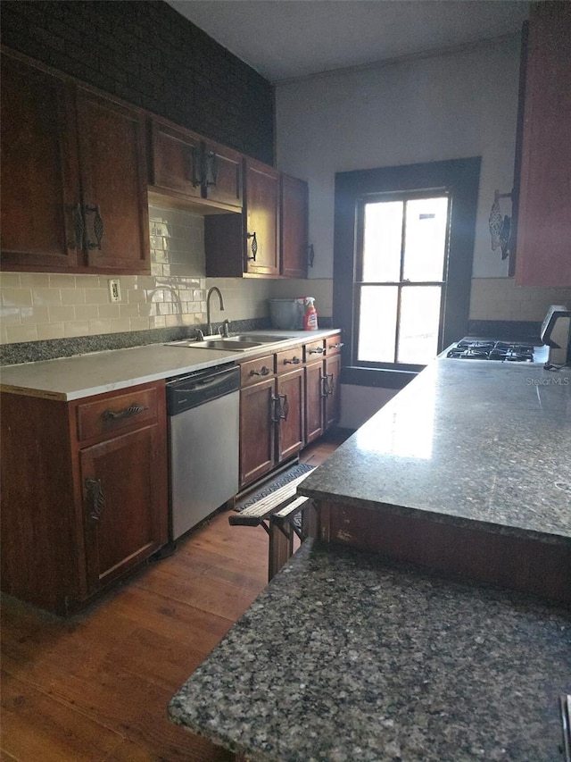 kitchen with dishwasher, sink, gas cooktop, dark hardwood / wood-style flooring, and backsplash