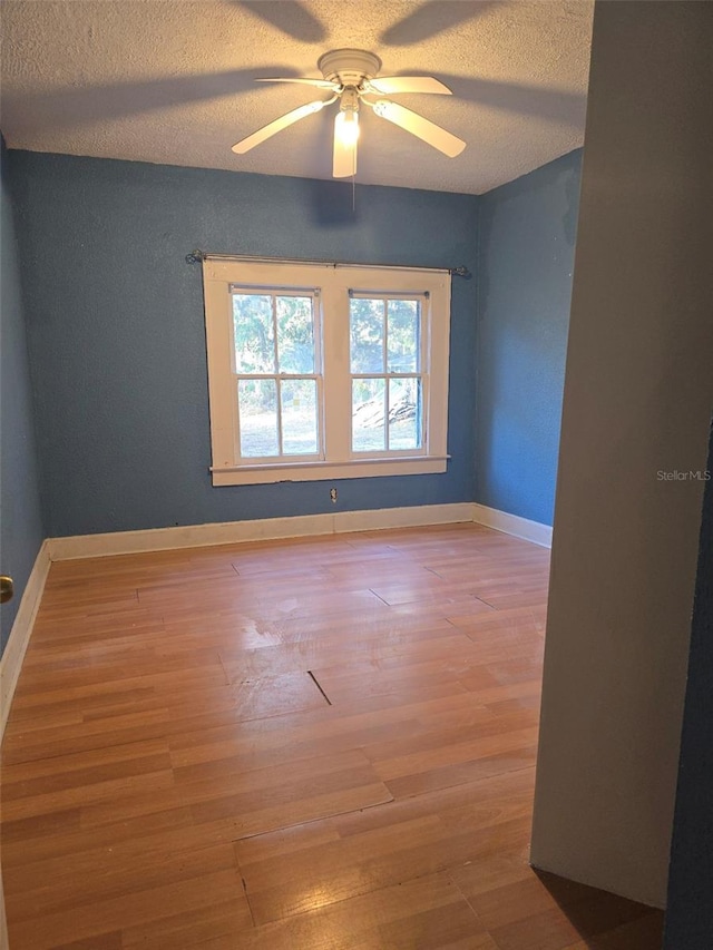 empty room with wood-type flooring, a textured ceiling, and ceiling fan